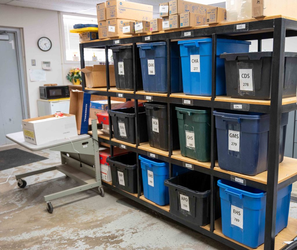 Organizational totes, labeled with each school's three-letter acronym