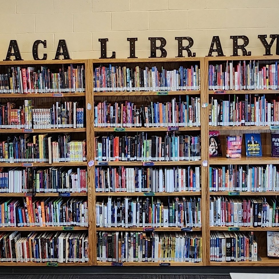 Bookshelves full of books with "ACA LIBRARY" sitting on top