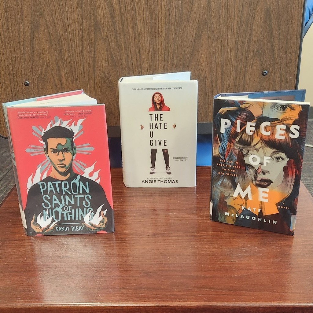 Display of Realistic Fiction books: Patron Saints of Nothing; The Hate U Give; Pieces of Me
