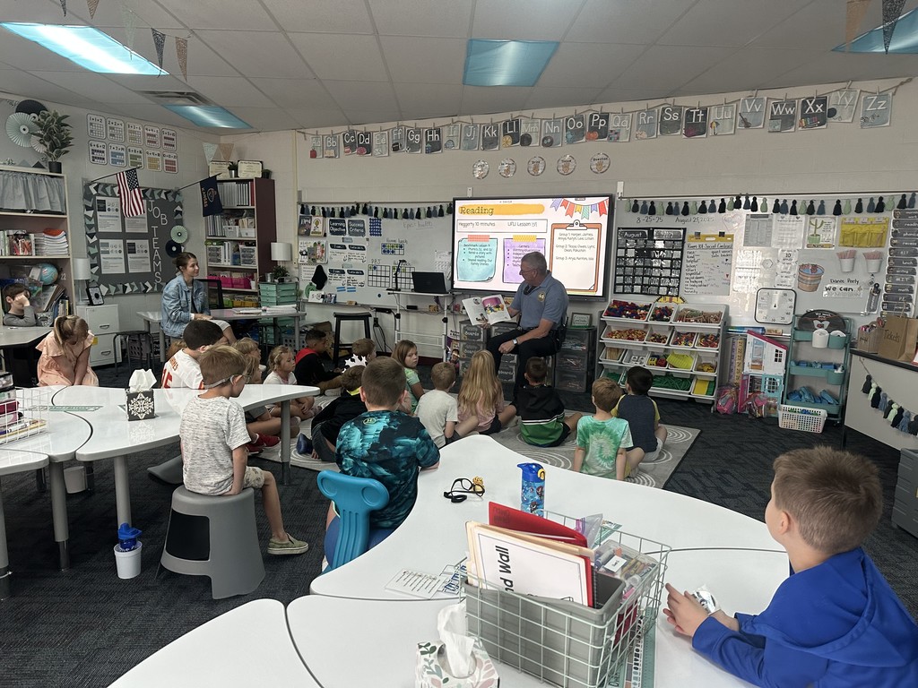 Officer Camp reading a story to 1st graders