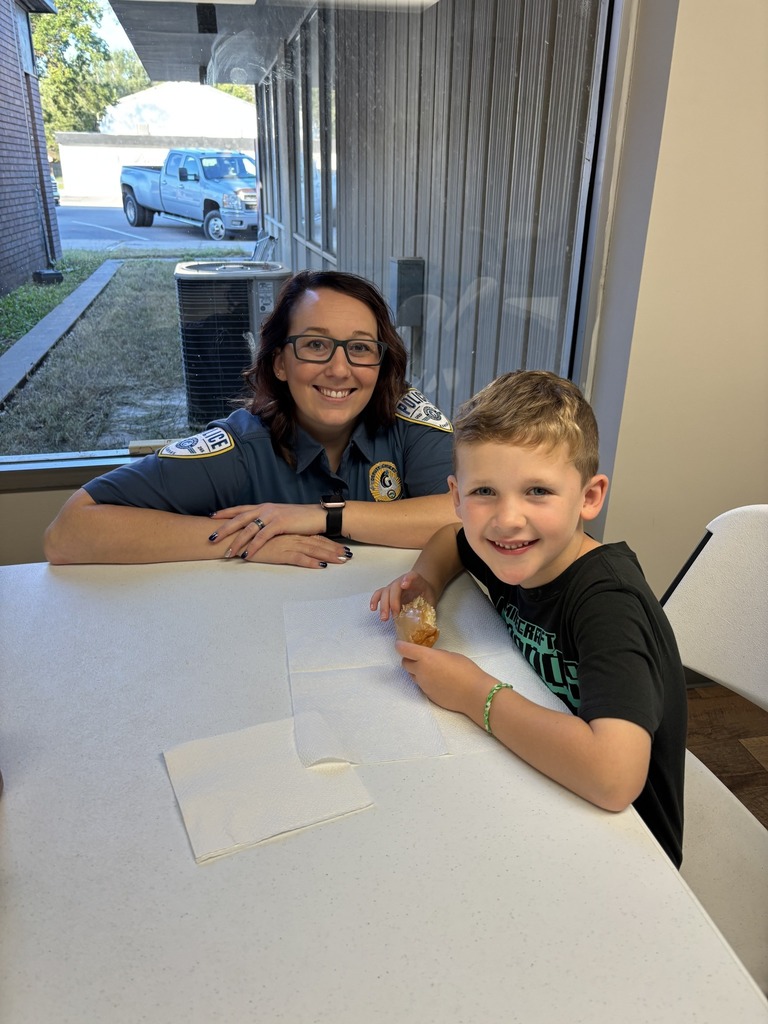Student eating a donut with a school officer