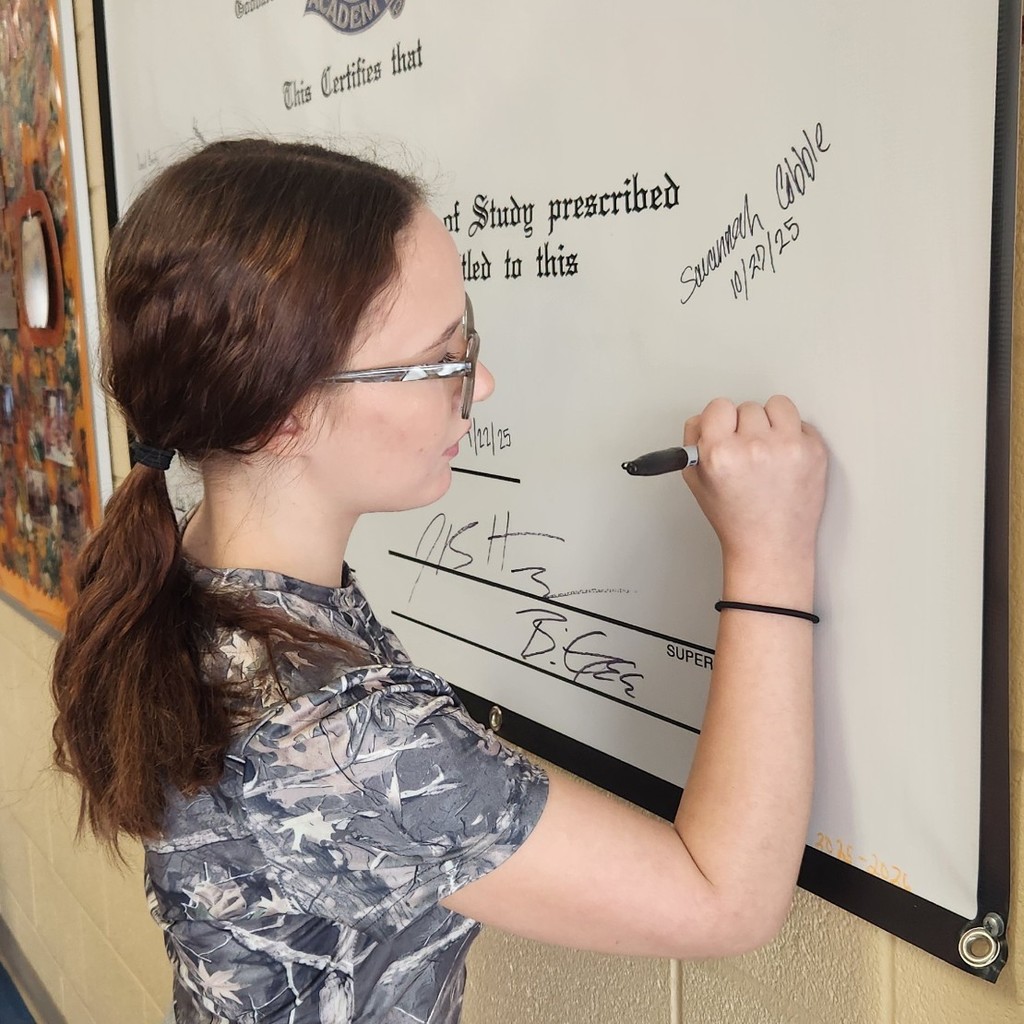 Makenna Alexander signing diploma