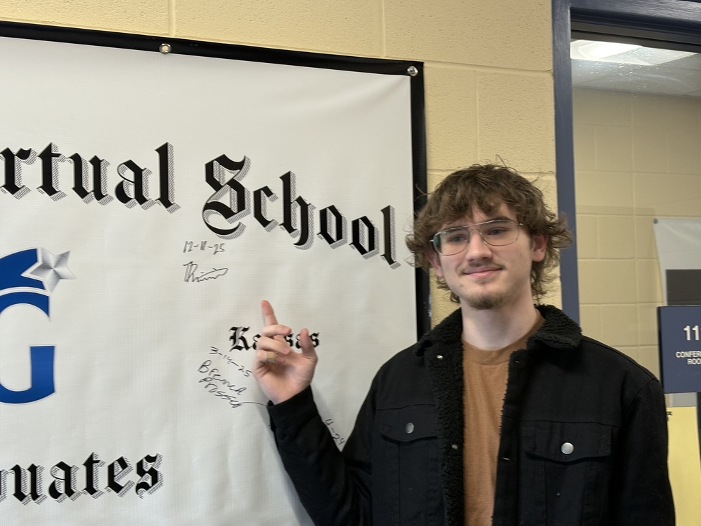 Student pointing at his signed name