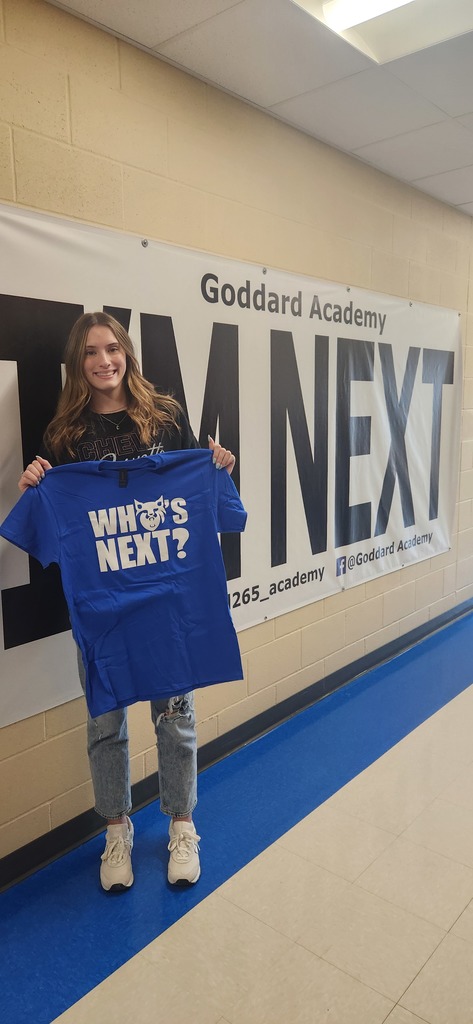 Student holding Whose Next Shirt in front of the I'm Next sign