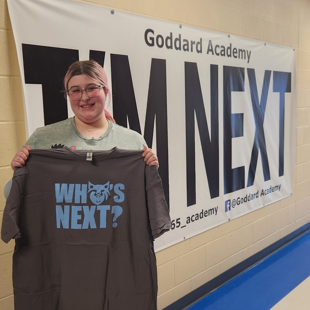 Holding "Who's next" shirt in front of I'm next Banner