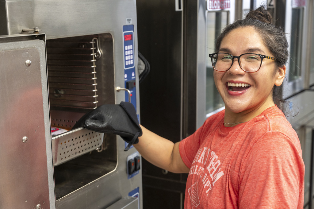 Member of the Nutrition Services team prepares dinner for attendees of the event