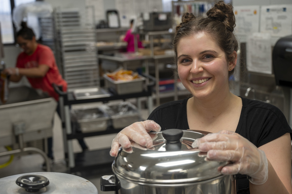 Member of the Nutrition Services team prepares dinner for attendees of the event