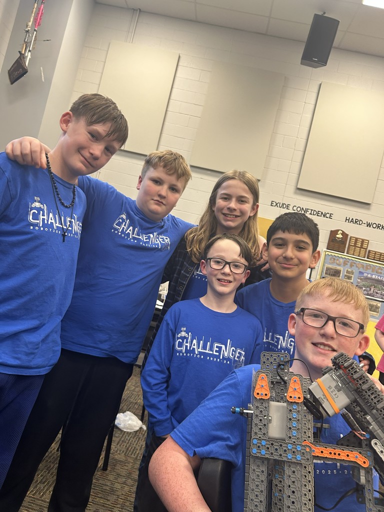 6 students posing for a picture with their robotics robot. 