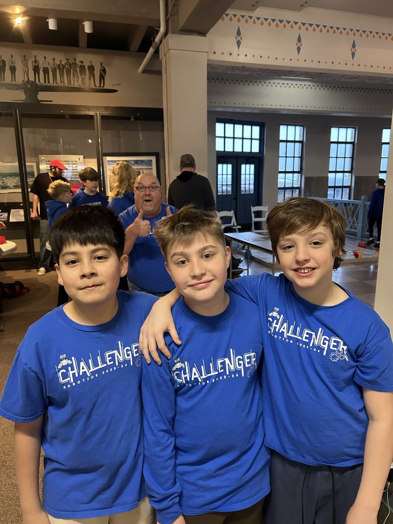 3 students posing for a picture wearing their challenger robotics outfits.