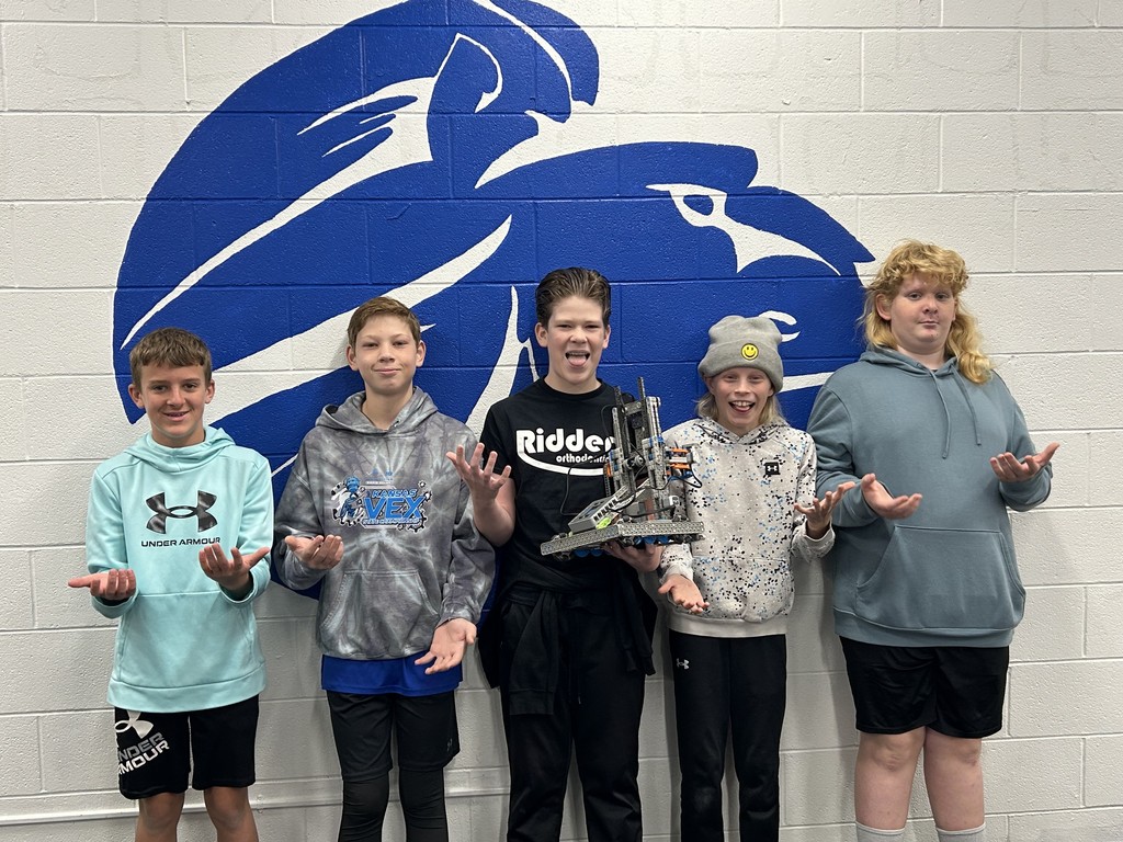 5 students posing for a group picture with their robot. 