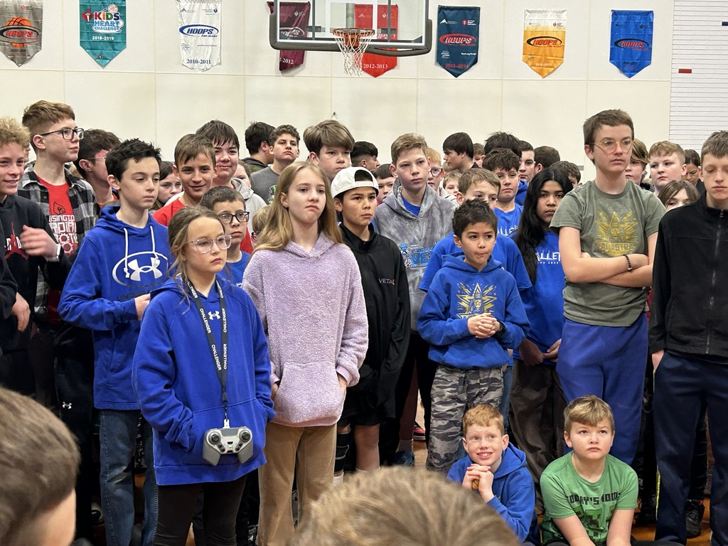 A group of students listening to the robotics speakers.