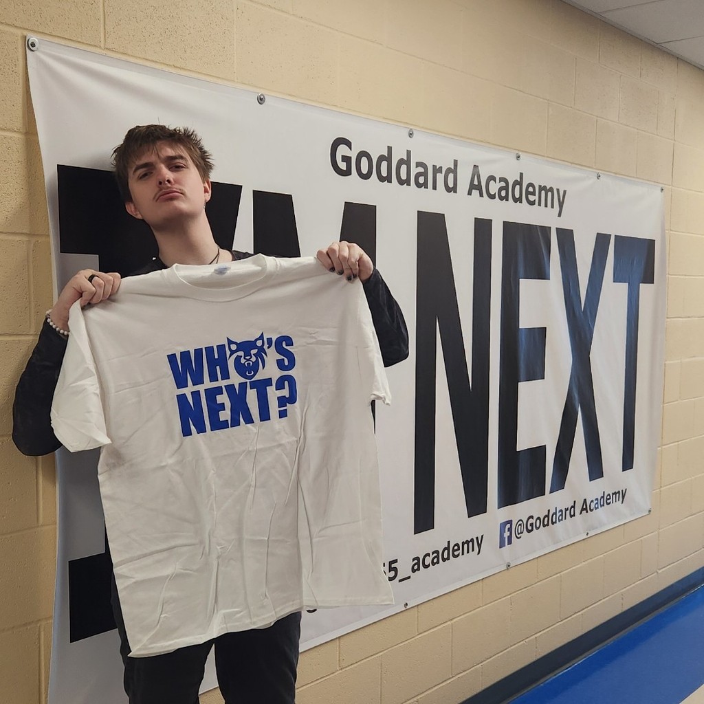 Lookin cool with "Who's Next?" shirt in front of "I'm Next" banner