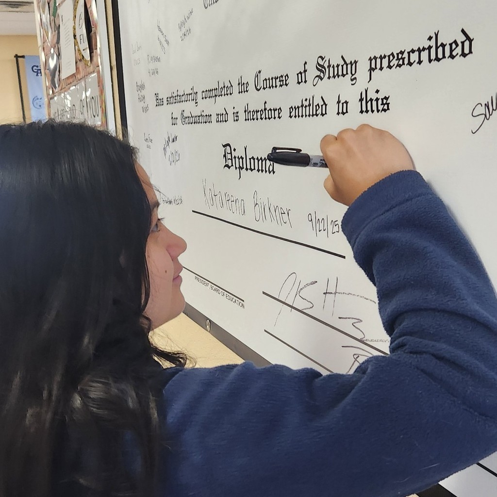 Anayeli Palacios signing diploma