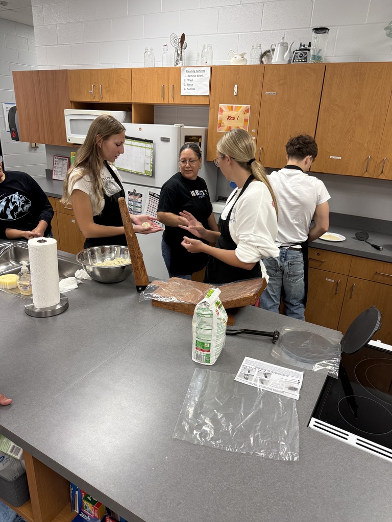 background:  culinary classroom with students rolling dough to make tortillas