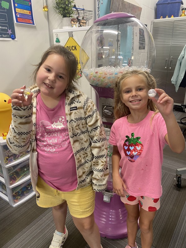 Kids holding up a gumball