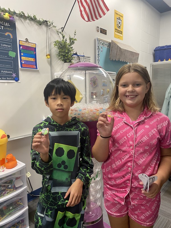 Kids holding up a gumball