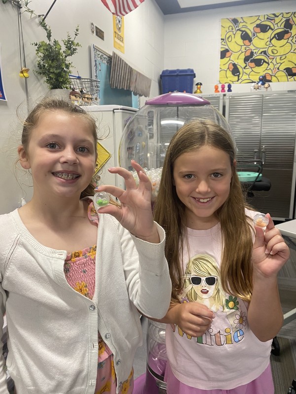 Kids holding up a gumball
