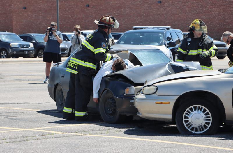 Rescue workers assess injuries to accident victims in mock DUI demonstration.