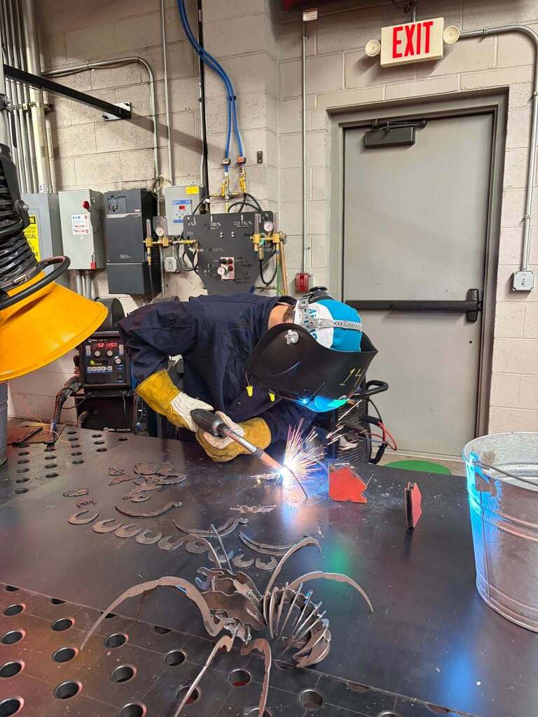 Student welder demonstrating welding