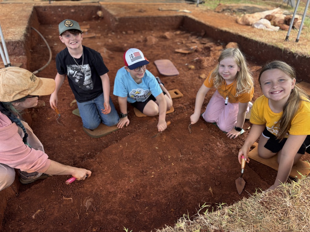 Students posing for a picture at an active archeological dig site 