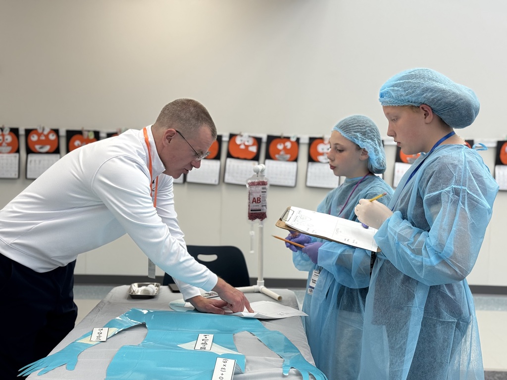 Two students working with an adult to solve math problems