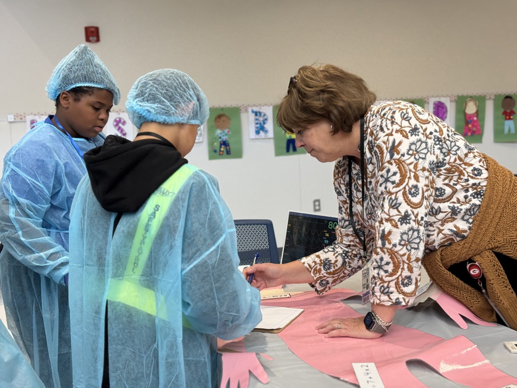Two students working with an adult to solve math problems