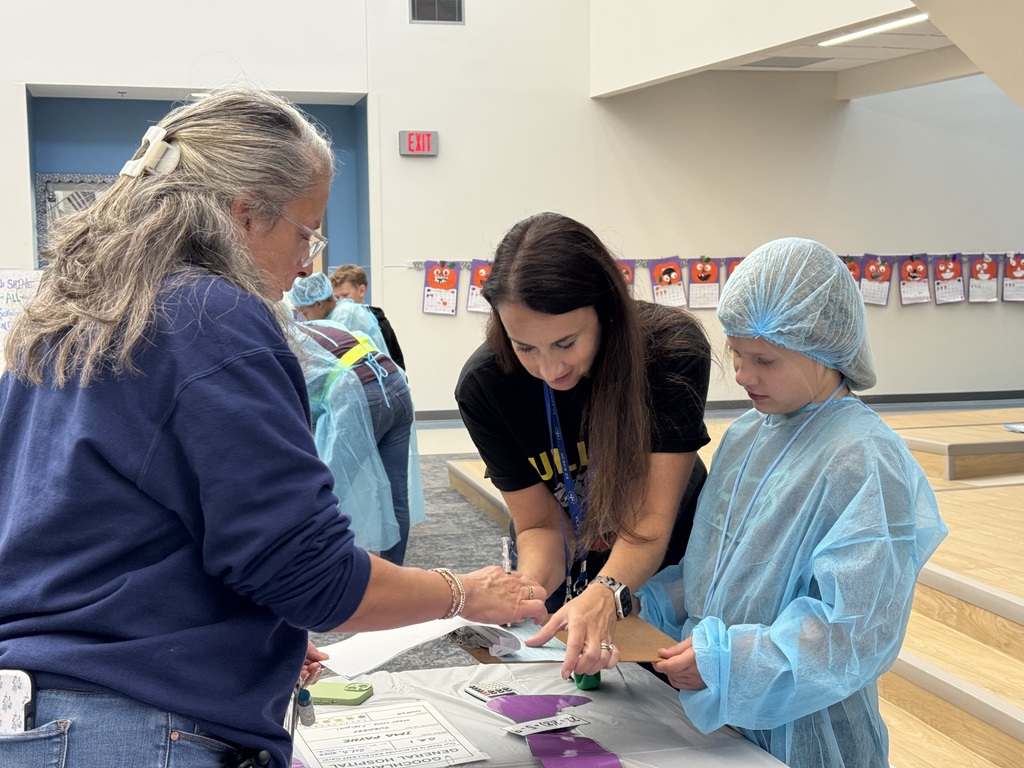 Student working with two adults to solve math problems