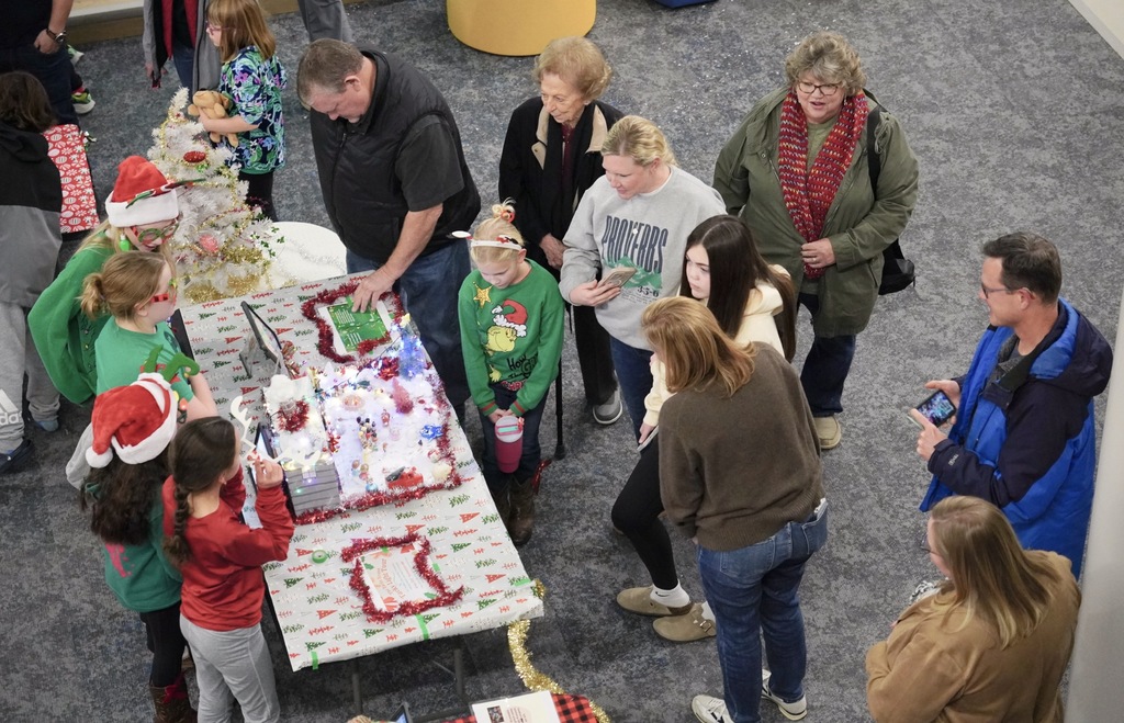 Group of students explaining their creation to a group of families and guests