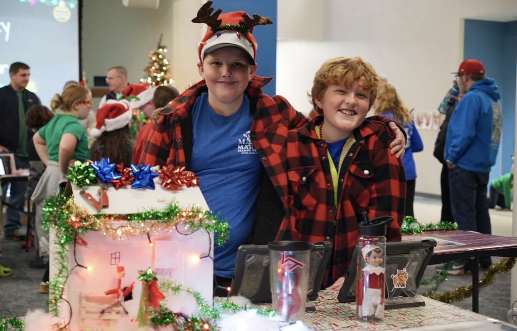Two students smiling showing off their project 