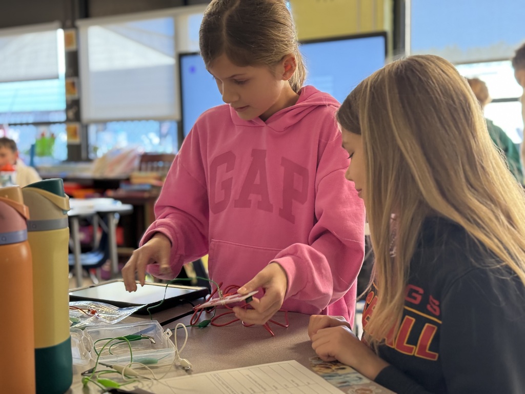 Two students working on testing insulators and conductors 