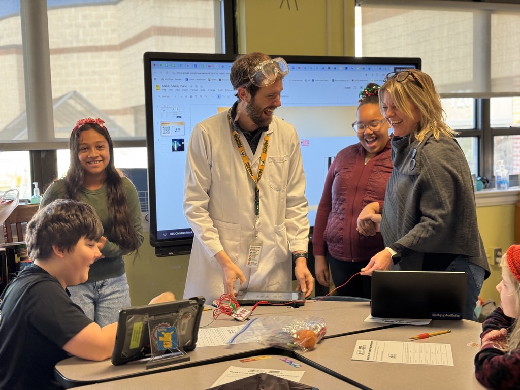 Mr. Mock, Mrs. Cosby, and students demonstrating how electricity can flow through people
