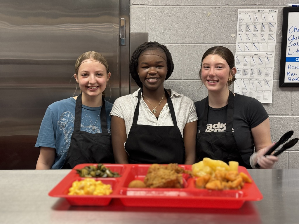 Students posing with tray of food in front of them