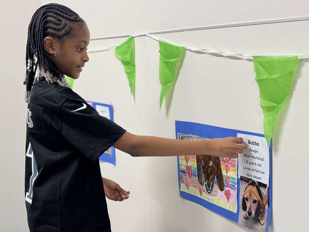 Student putting a sticker on a poster