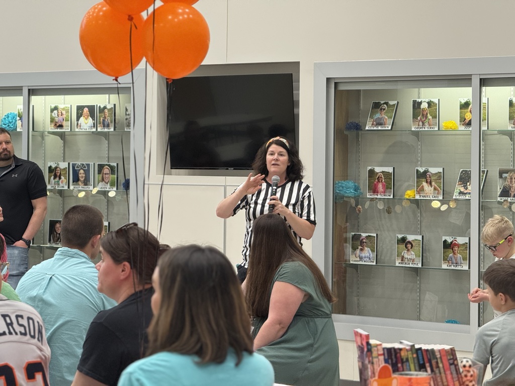 Teacher speaking to a group of people with a microphone