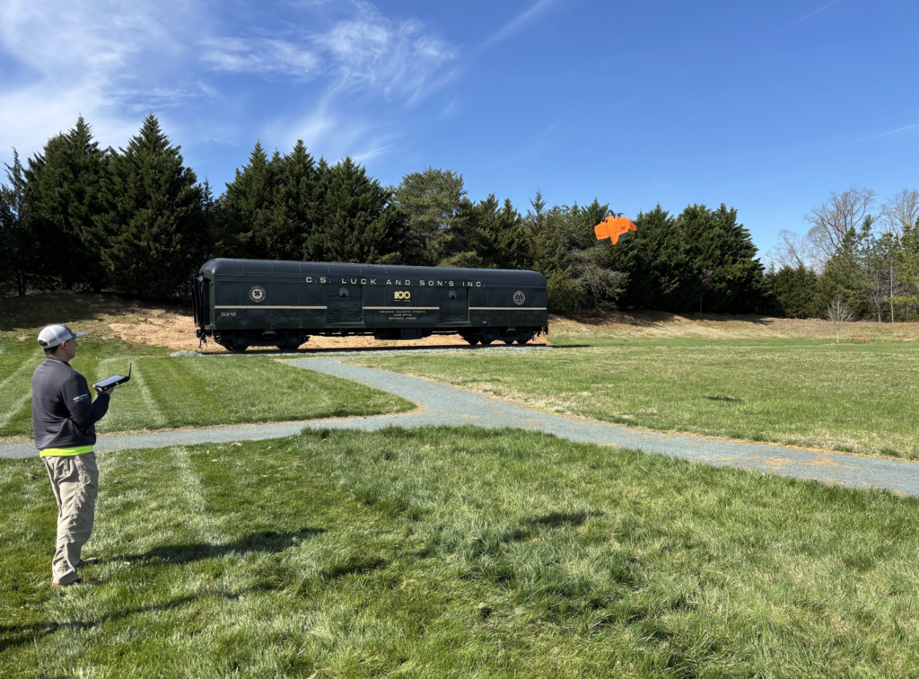 Drone operator landing orange drone