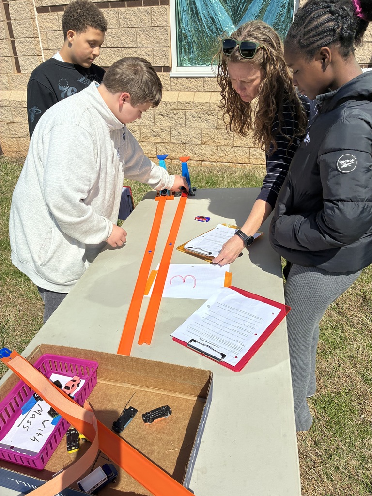 Students look at science station instructions