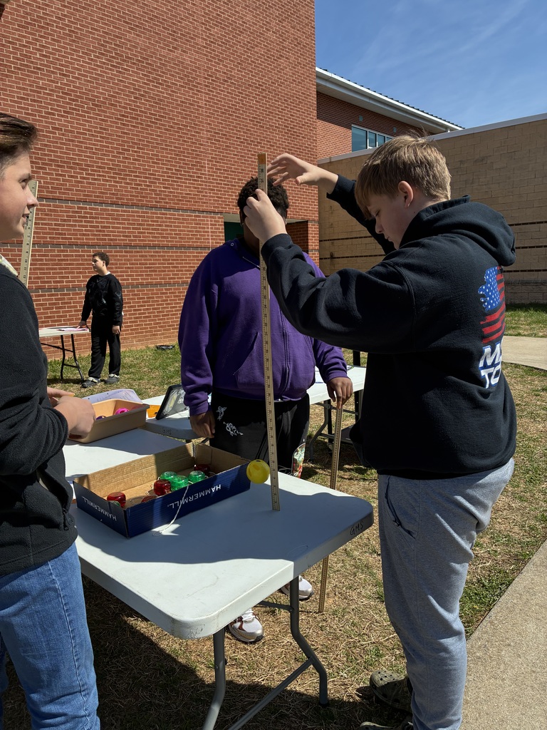 Students measure how fast whiffle ball drops with yard stick