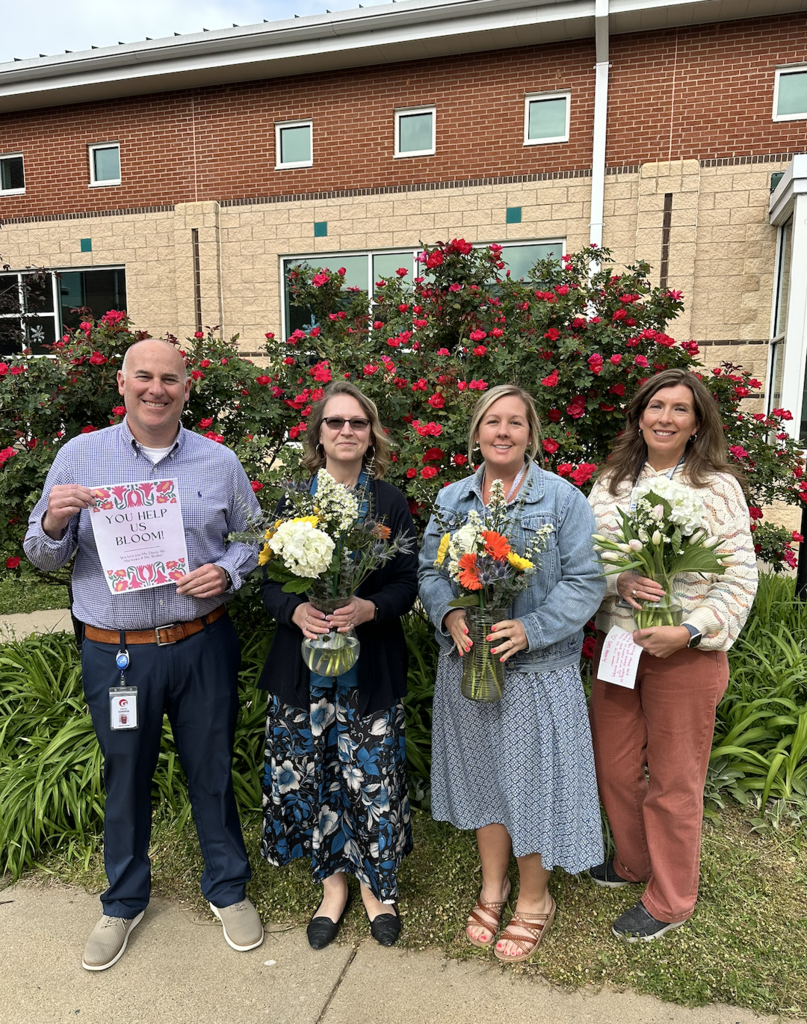 Mr. Gordon, Ms. Matthews, Ms. Davis, and Ms. Weller posing with their bouquets