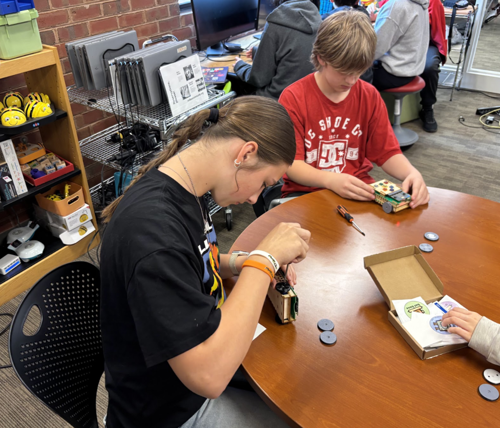 Students adding wheels to Roversa Robots