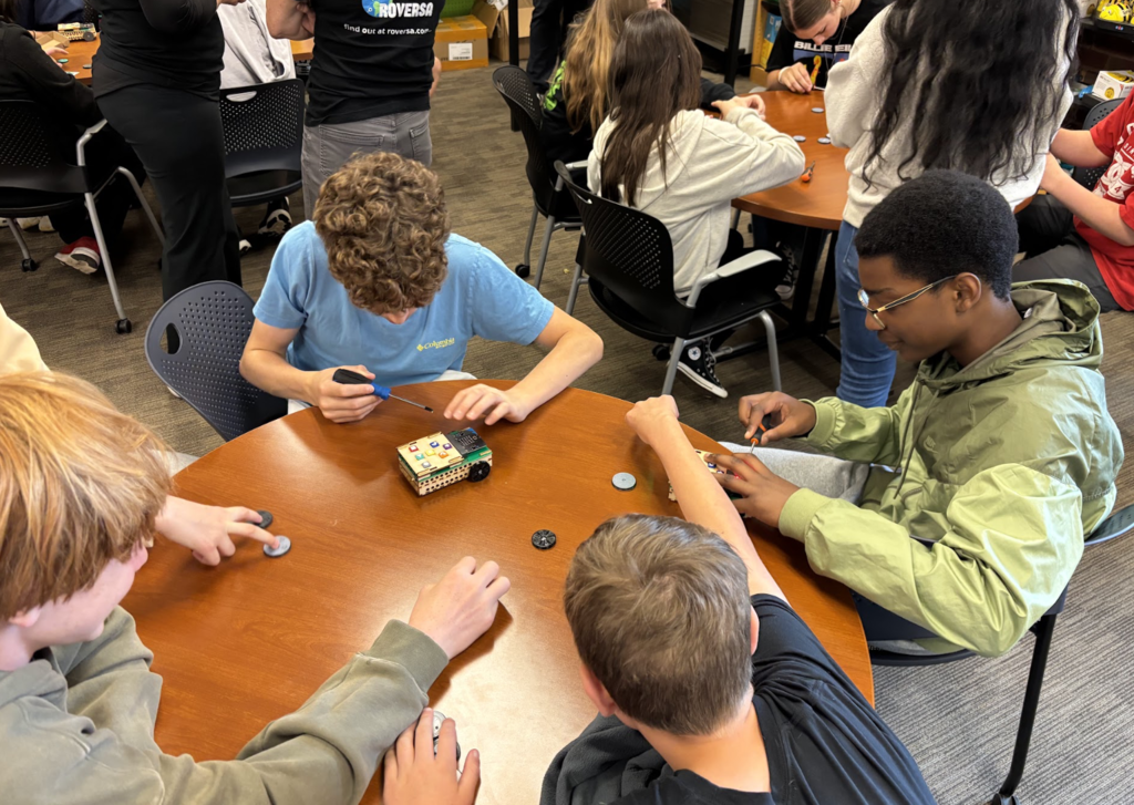 Students working on adding wheels to Roversa Robots