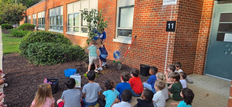 students observing the planting of the survivor tree