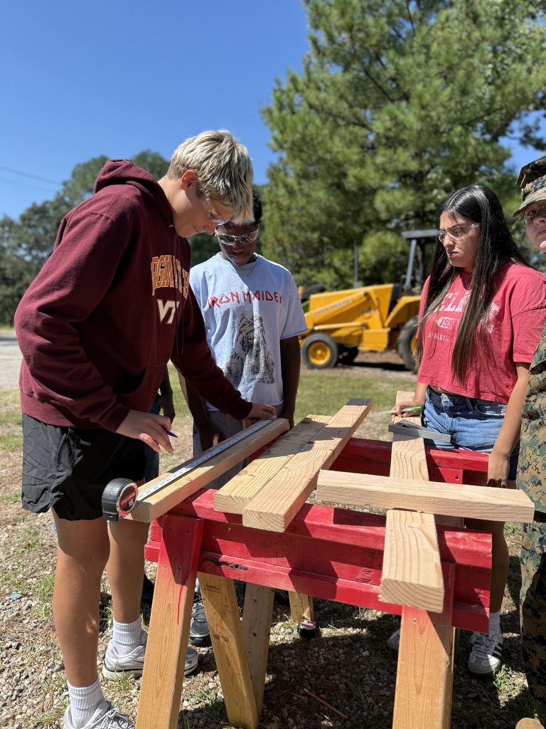 student measuring wood