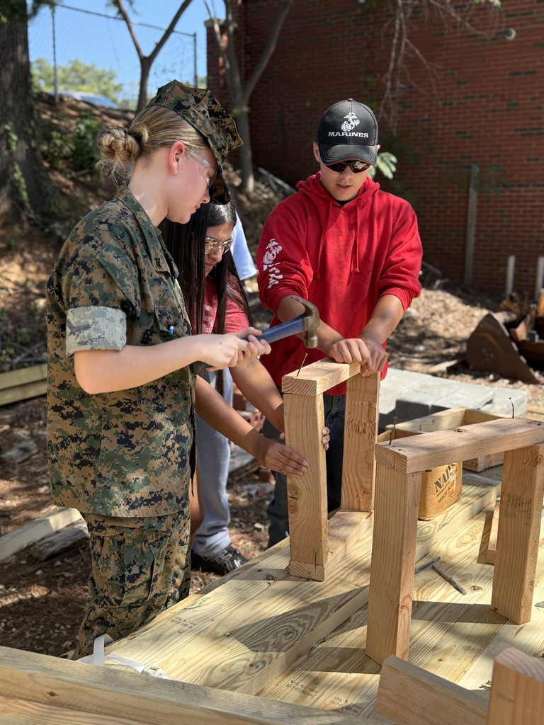 student hammering a nail into wood