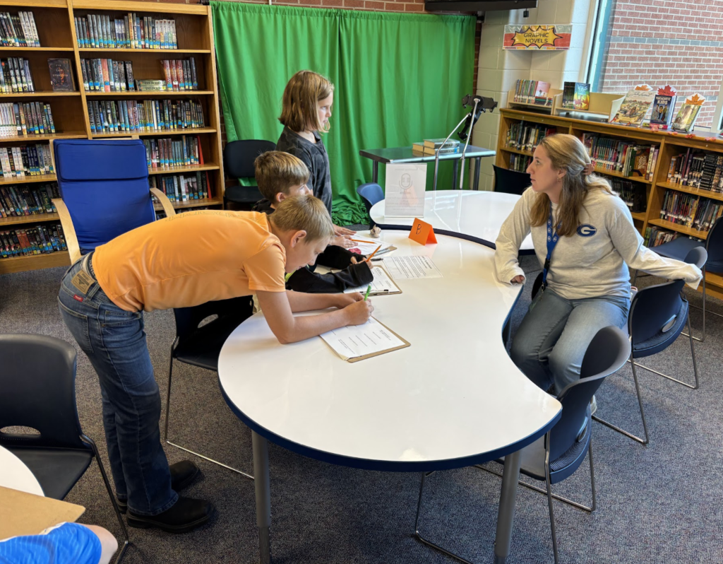 Ms. Voss talks to students about a source for their research