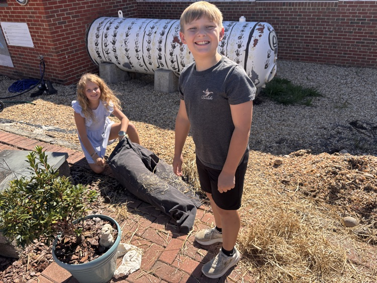 two students working on stuffing the scarecrow