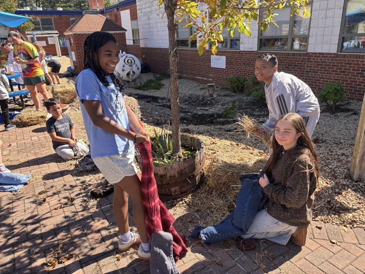 A group of students works together to stuff their scarecrow
