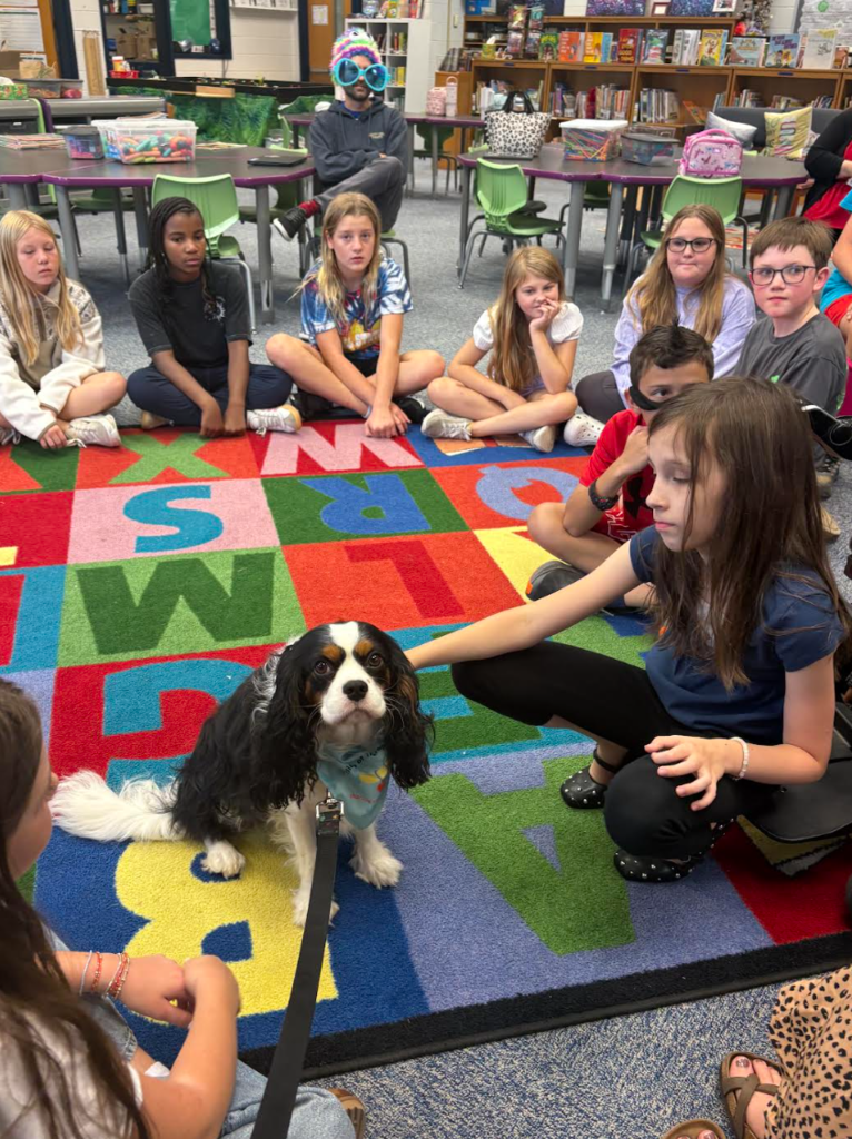 5th graders petting Dawson while they listen to a story