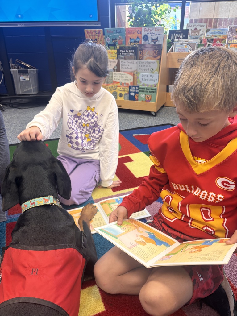 Student reading to Pi, the Reading Therapy Dog