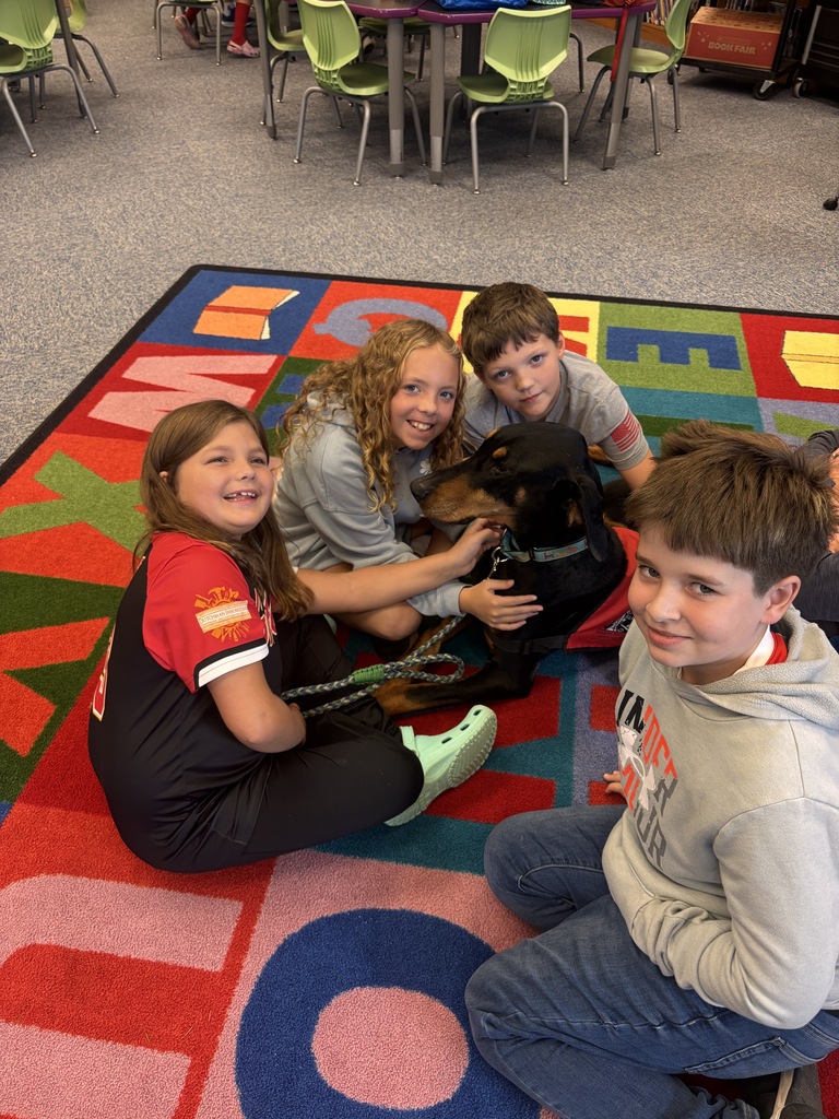 Students petting the Reading Therapy Dog, Pi
