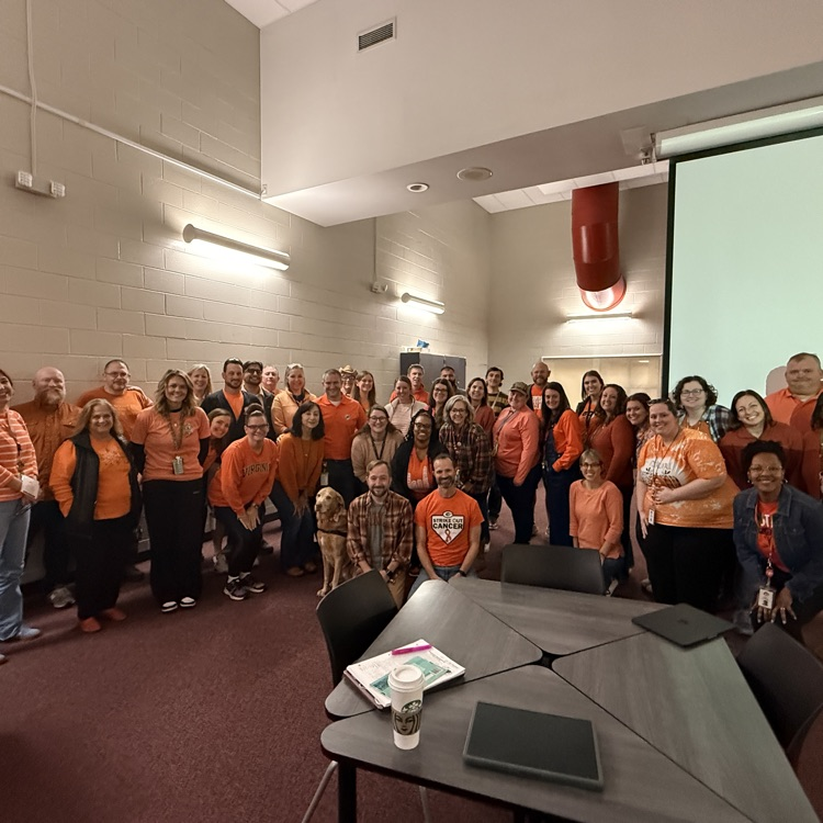 staff members together all wearing orange 